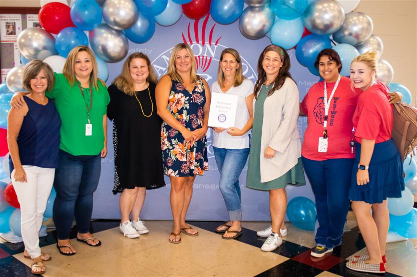 A group of teachers smile
